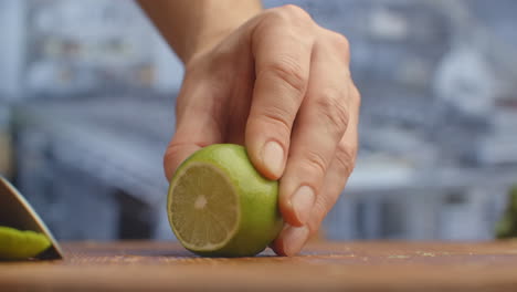 Cut-with-a-knife-on-a-wooden-board-closeup-green-lime-in-the-kitchen.-shred